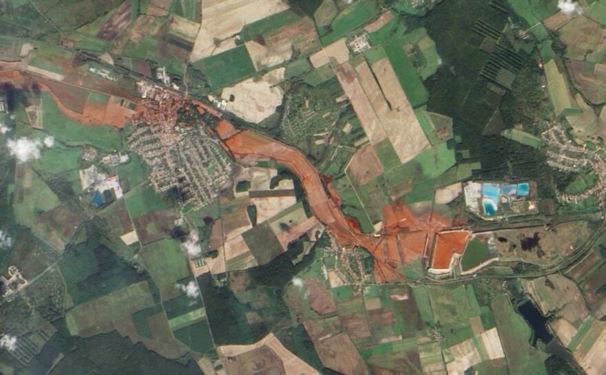 Aerial view of the toxic red sludge flowing from a breached waste reservoir (diamond shape at right) through the villages of Kolontar and Devecser.