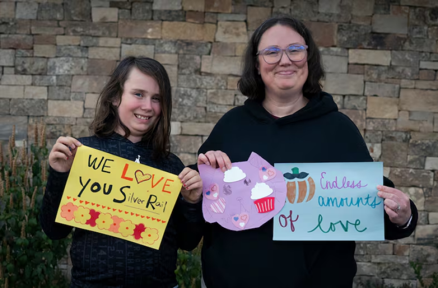 Amy Banton, 37, left, and her son Wallace "Wally" Banton, 10, show the art they made in support of the Silver Rail Elementary community on Oct. 20, 2026 in Bend, Ore.