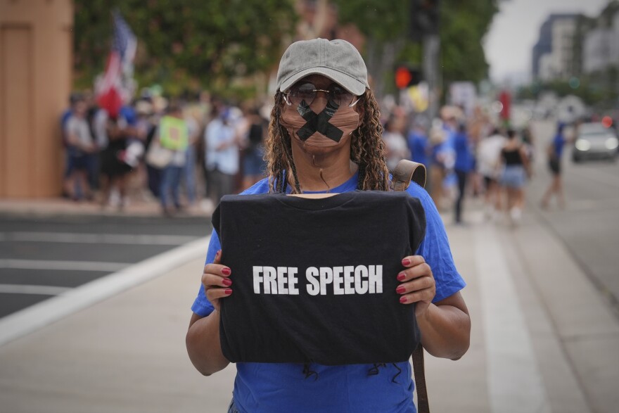Melody Cooper holds a "Free Speech" sign at a demonstration in response to the suspension of Jimmy Kimmel's late-night show outside of The Walt Disney Studios Thursday, Sept. 18, 2025, in Burbank, Calif. (AP Photo/Jae C. Hong)