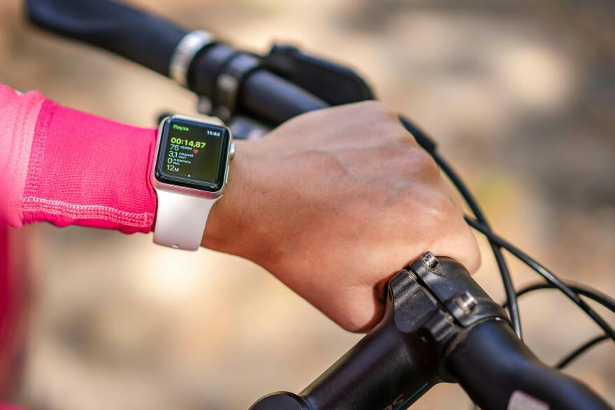 A cyclist with a wearable fitness tracker.