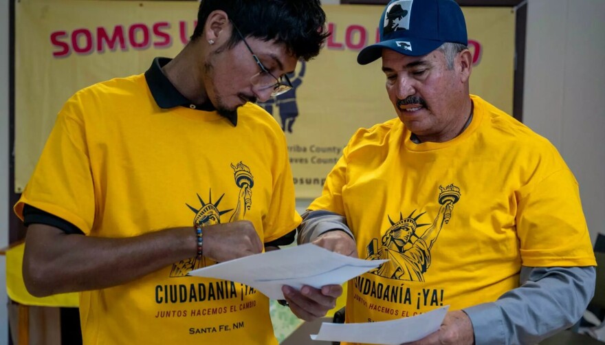 Crisanto Alavos, right, gets help from Eleazar Flores with a sample ballot at Somos un Pueblo Unido in Santa Fe in this October 2024 file photo. Somos un Pueblo Unido is one of several organizations sending staff to complete immigration law training through a new program offered by the New Mexico Department of Workforce Solutions.