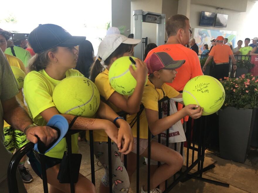Campers from a tennis camp near Chicago wait in line for autographs in Mason.