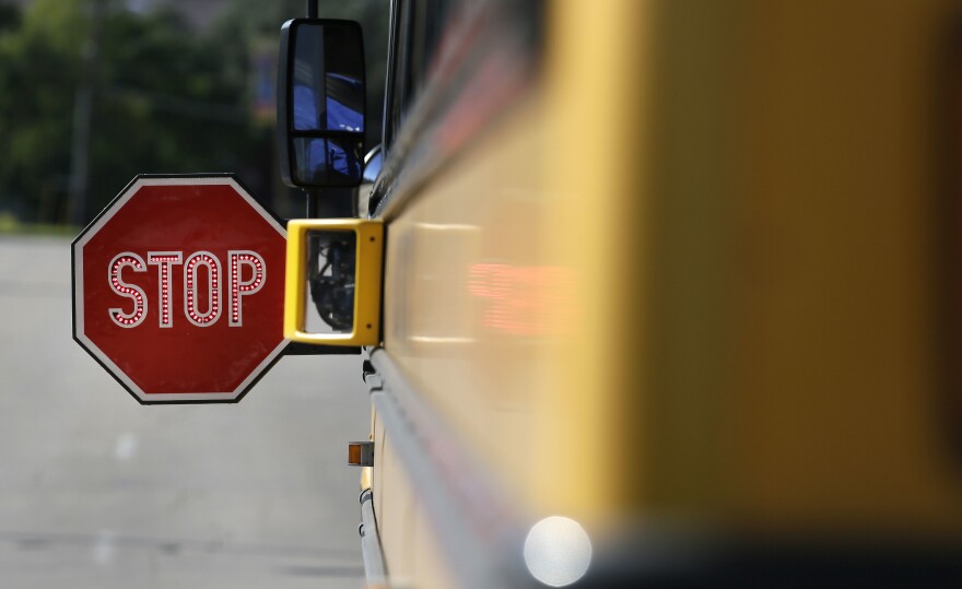 A stop sign extends from a school bus. 