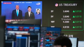 U.S. President Donald Trump, left, and South Korean President Lee Jae Myung are seen on a screen at the foreign exchange dealing room of the Hana Bank headquarters in Seoul, South Korea, Tuesday, Jan. 27, 2026. (AP Photo/Ahn Young-joon)