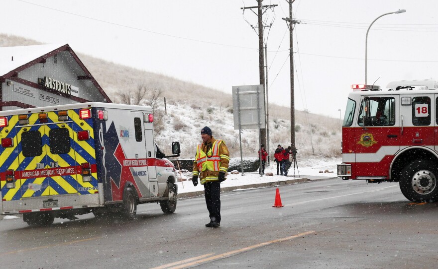 An ambulance proceeds Friday up a secured road leading to a Planned Parenthood center in Colorado Springs, Colo., after reports of an active shooter.