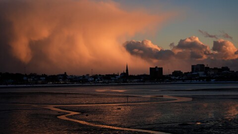 Storm clouds that had brought brief snow flurries begin to clear, Tuesday, Jan. 20, 2026, over Portland, Maine.