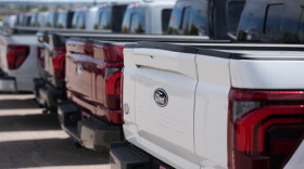 Unsold 2026 F-150 pickup trucks sit in a long line outside a Ford dealership on April 12, 2026, in Centennial, Colo.