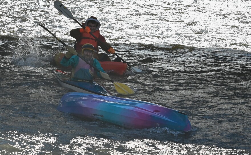 Paddlers on the Lackawanna River work to push an empty kayak back to shore. No one was in the kayak when the river's current picked it up.