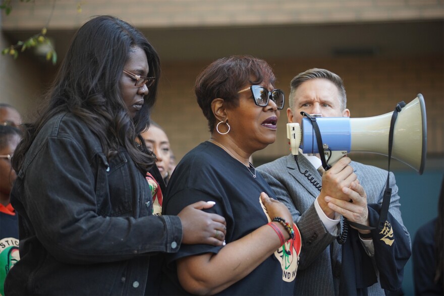 Jayland Walker's mother, Pamela Walker (center), speaks to demonstrators following a march through downtown Akron on Monday, Oct. 10, 2022. She's held by Jayland Walker's sister, Jada Walker.
