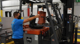 A worker sprays down a forklift in an Elkhart factory in accordance with the company's COVID-19 safety standards.