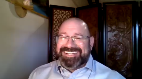 Man with blue shirt talking