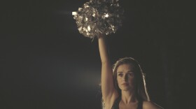 Lacy Thibodeaux standing with pom poms in the air. (Photo by Yu Gu)