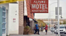 Investigators exit the Alpine Motel, where six residents died in a fire.