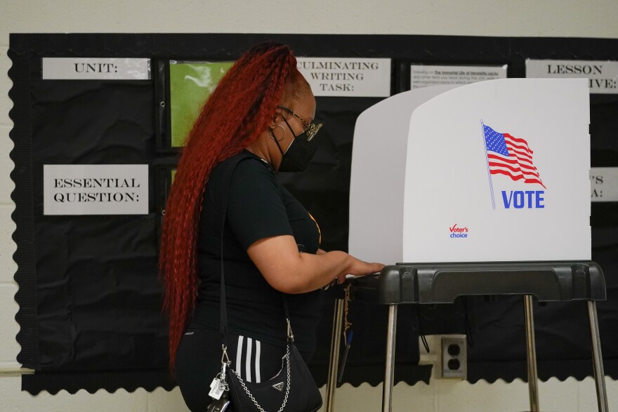 Asia Rogers uses a privacy booth to cast her vote at Edmondson Westside High School during Maryland's primary election, Tuesday, July 19, 2022, in Baltimore. (AP Photo/Julio Cortez)