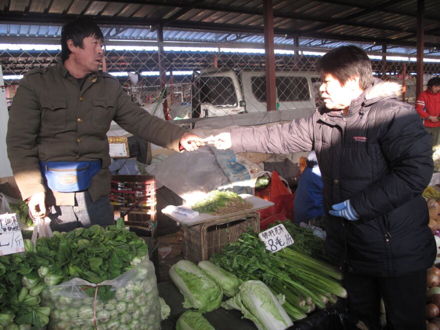 "We may be dissatisfied, but we still need to eat," says Xu Shengru, buying  cabbage -- which she says has doubled in price -- at a Beijing market.