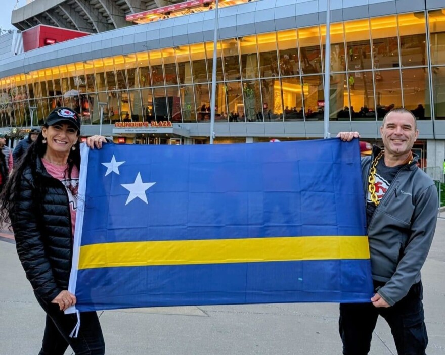 Sonya Kieffer, left, is originally from Kansas City but has lived in Curaçao for more than two decades. During an October visit to Kansas City, she waved the Curaçao flag during a Chiefs game at Arrowhead Stadium.