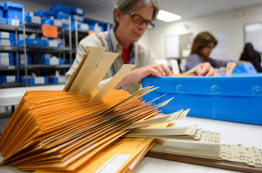  A clerk in Travis County goes through mail-in ballot packages in Travis County in 2014.