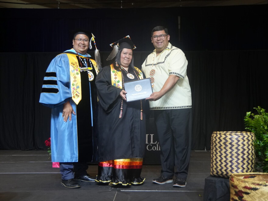 Tina Hickman (center) celebrates her graduation from Bay Mills Community College with Duane Bedell, the school’s president and CEO (left) and Mississippi Band of Choctaw Indians chief Cyrus Ben (right) on June 3, 2026. BMCC held a graduation in Choctaw, MS, for students taking classes online, like Hickman.