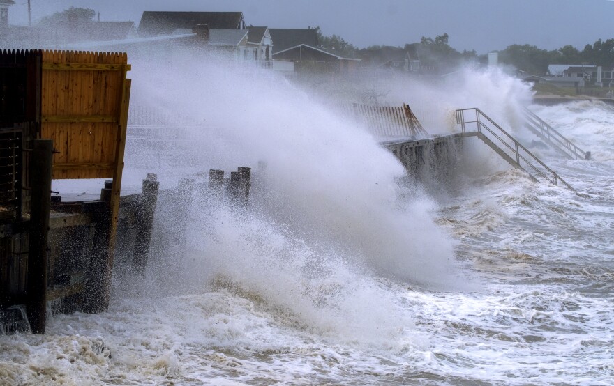 A photo of ocean waves crashing against houses