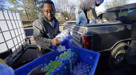 Madonna Manor maintenance supervisor Lamar Jackson left, stacks bottled water brought by Mac Epps of Mississippi Move, as part of the supply efforts by city councilman and State Rep. De'Keither Stamps to a senior residence in west Jackson, Miss. (Rogelio V. Solis/AP Photo)