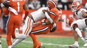 Clemson defensive end Justin Mascoll, right, forces a fumble on Syracuse quarterback Garrett Shrader during the first half of an NCAA college football game in Syracuse, N.Y., Saturday, Sept. 30, 2023. Clemson recovered the ball. (AP Photo/Adrian Kraus)