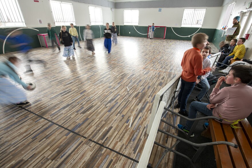 Students at Voznesenka School play a game of soccer in the school’s half-size gym. Up-ended card tables create a temporary spectator bench.