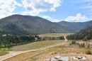 The view looking south from atop the 'Hecla Heap,' a pile of mining tailings left by the most recent mining period, which ended in the mid-1990s. Perpetua plans to remove and reprocess the tailings to extract remaining gold, and create a new mining area here called the 'Hangar Flats pit' to mine the hillside above (not pictured but to the right). In the distance is where Perpetua plans its tailings storage, though it will create a lined and buttressed area to prevent contamination. Meadow Creek, also in the picture, will be re-routed.