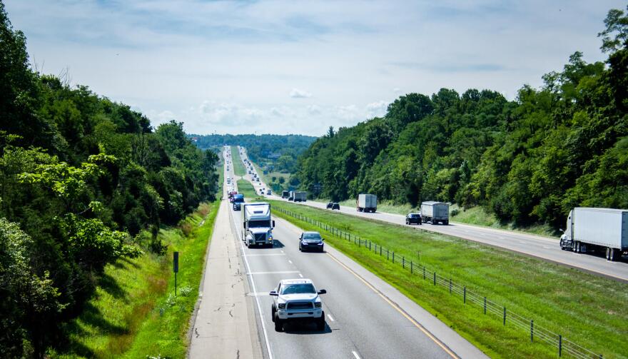 summertime view of a highway with trucks, cars and semis