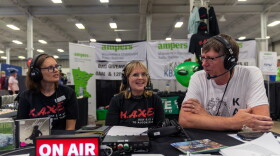 KAXE Morning Show producer Jennifer Barr, left, Director of Content and Public Affairs Heidi Holtan, and volunteer Mark Klabunde chat during an interview broadcast live Aug. 28, 2026, from the Minnesota State Fair.