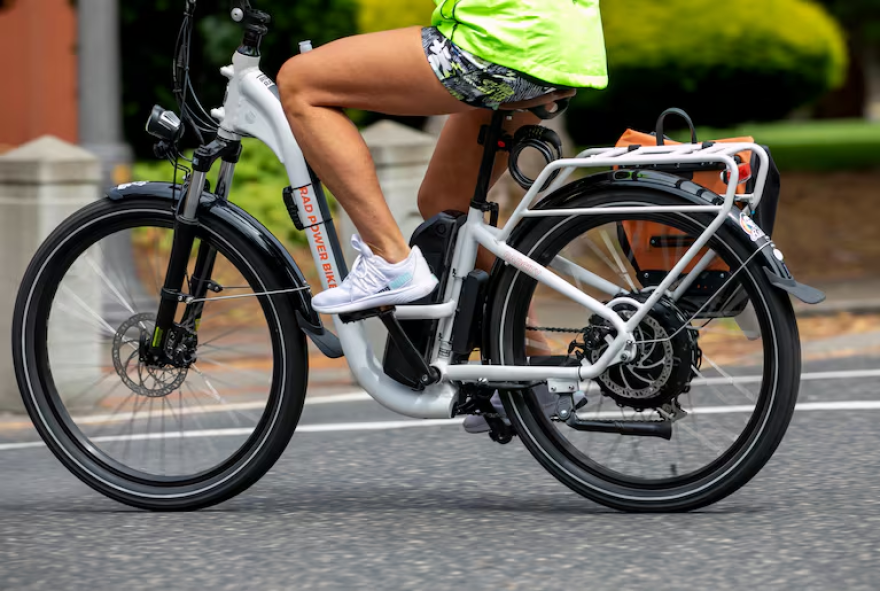 A person rides an e-bike in Vancouver, Wash., on June 29, 2024.