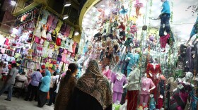 Nighttime shoppers pause to look at a display at Cairo's Ataba market in May 2011. The government says shops must close earlier in order to save scarce electricity, but many Cairo residents are complaining.