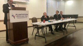 At the table are three of the five mayoral candidates: Lynn Stoner, Aron Davis, and Peter Tingom. 