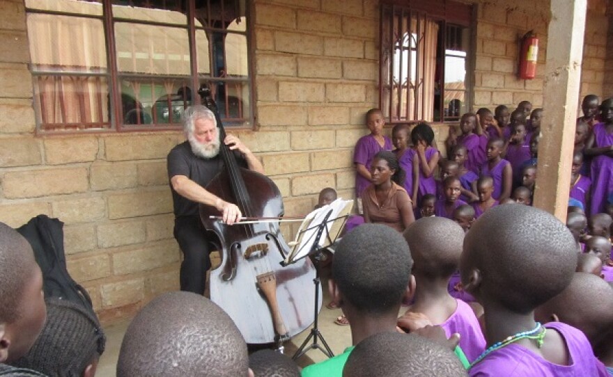 photo of Dobbs playing the double bass for a group of children