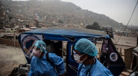 Health workers arrive in a tuk-tuk to administer doses of the Pfizer COVID-19 vaccine to elderly citizens in their homes in Lima, Peru, in April.