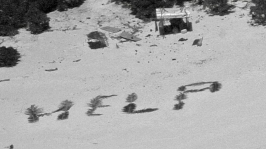 The 'HELP' sign made from palm fronds is shown on the Pikelot atoll.