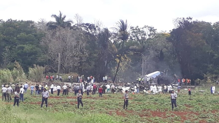 First responders and law enforcement gather in the field where an airliner crashed after takeoff Friday, just outside the international airport in Havana, Cuba.