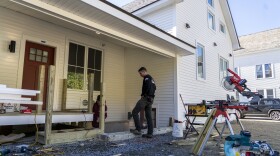 Two people talk outside a building under construction