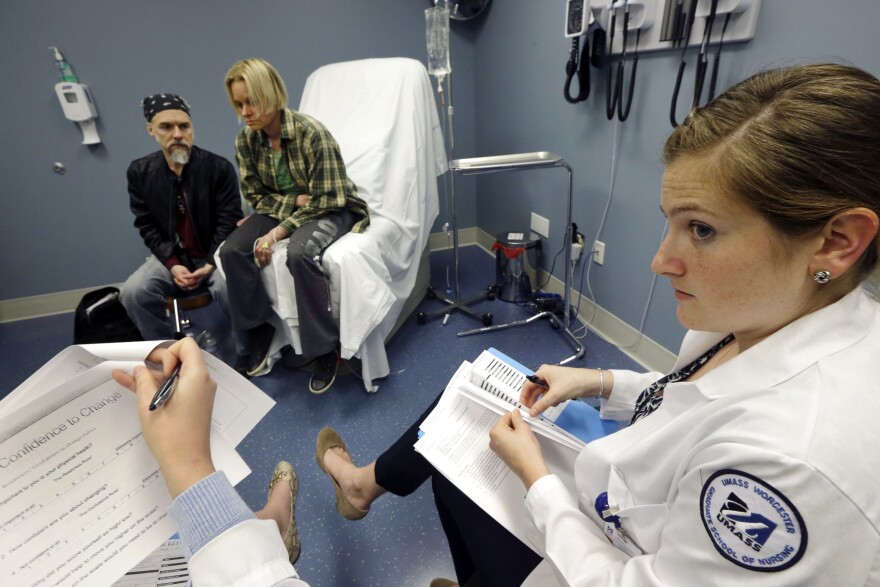 In this May 11, 2016 photo, University of Massachusetts Medical School nursing student Morgan Brescia, right, and others attend a simulation of treatment for a patient coping with addiction during class at the medical school in Worcester, Mass.