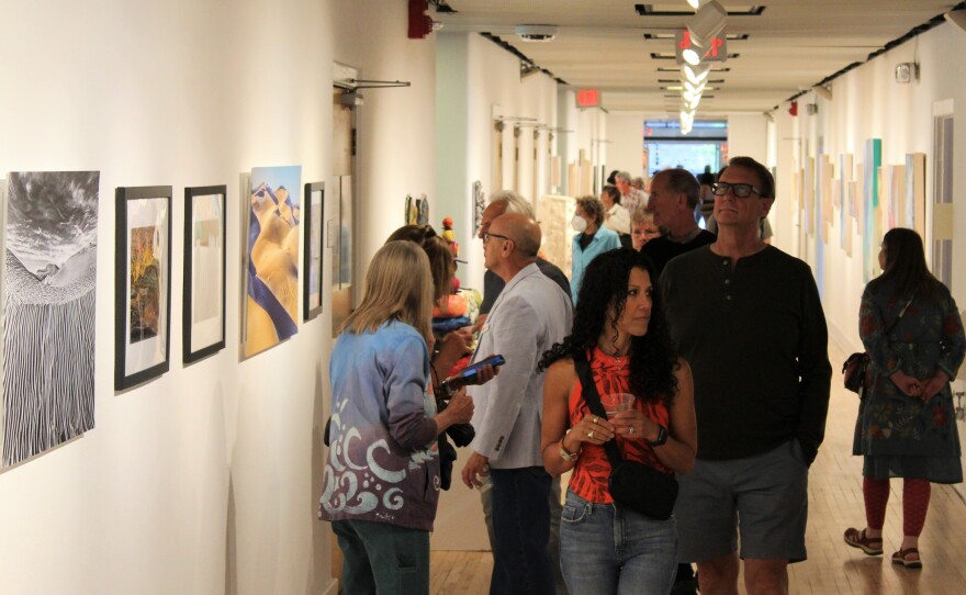 Visitors mingle with artists at the "Round and Around" exhibition on opening night, June 2.
