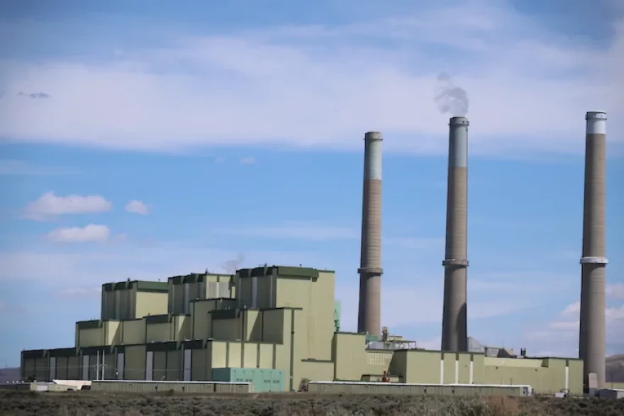 A large power plant with smoke stacks.