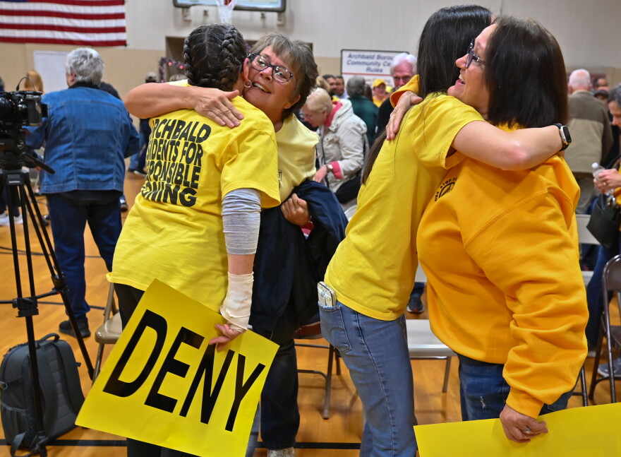 Members of the Archbald community hug each other after borough council denied a data center campus developer's zoning application.