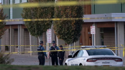 Officers behind yellow caution tape outside a school.
