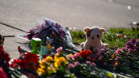 A stuffed animal and other items mark a makeshift memorial in front of Silver Rail Elementary School.