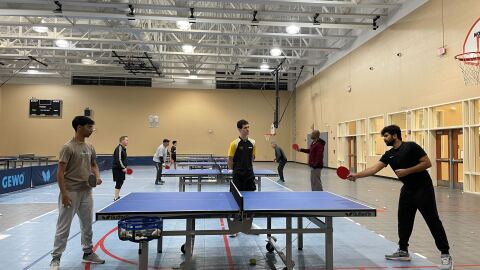 Carolina Pong founder Tripp Roche, middle, watches as table tennis players play at St. Andrews gym in Columbia, S.C. on Dec. 1, 2025.