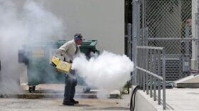 A Miami-Dade County mosquito control worker sprays around a school in the Wynwood area of Miami on Monday, Aug. 1, 2016. The CDC has issued a new advisory that says pregnant women should not travel a Zika-stricken part of Miami, and pregnant women who live there should take steps to prevent mosquito bites and sexual spread of the virus. (AP Photo/Alan Diaz)