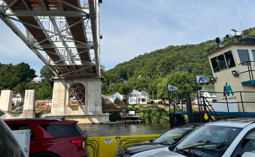 The Lansing Ferry crosses below the Mississippi River Bridge being constructed at the site on July 30.