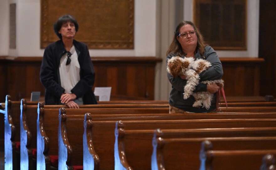 Donna Ammenhauser holds Joy, her 8-month old rescue dog, during St. Luke's blessing of the animals.