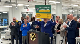 Senate Majority Leader Chuck Schumer, D-NY raises a sign that reads NY Semiconductor Superhighway during a news conference on Tuesday, July 2, 2024, at Monroe Community College announcing the Buffalo-Rochester-Syracuse corridor had been awarded $40 million in federal funding under the CHIPS and Science Act to develop a tech hug bolstering the semiconductor industry.