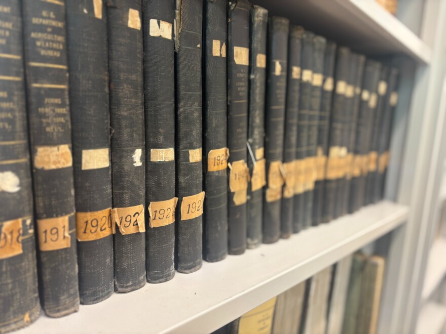 Weather records from the early 1900s are stacked on a bookshelf in State Climatologist Zack Leasor's office in Columbia, Missouri.