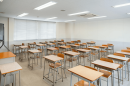 empty brown and metal classic classroom desks lined up in 6 rows 
